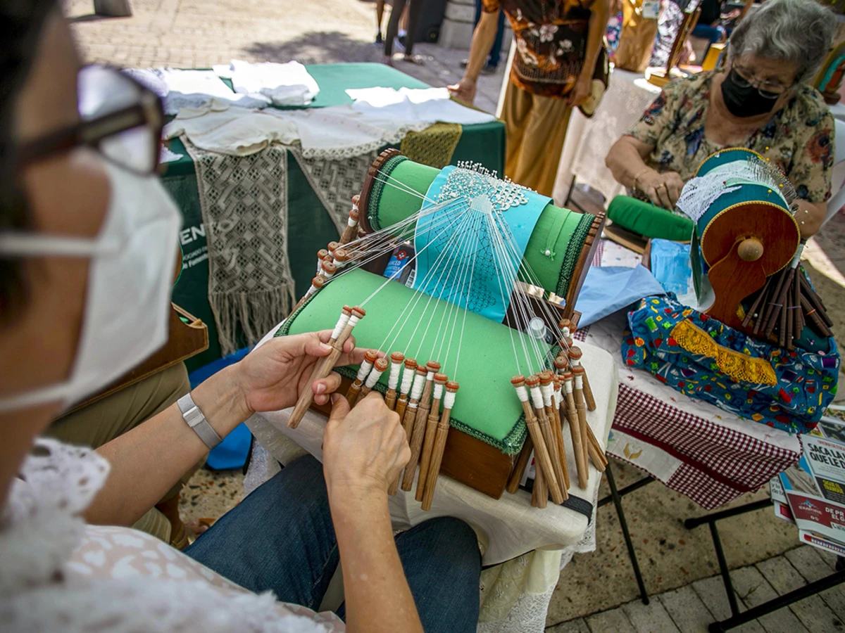 Carmen Arteaga demonstrates the intricate bobbin lace-making technique called mundillo, or “little world.” Guatemalan and Puerto Rican designers are leading textile workshops for Taller Puertorriqueño’s Tramando. Photo by Xavier Garcia, courtesy of Taller Puertorriqueño.&nbsp;