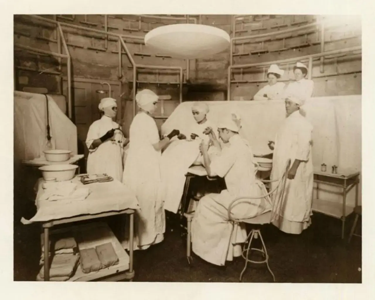 Carrie Pearson; Elizabeth Rae; Dr. Ella M. Russell; Dr. Stewart; Dr. Dunlap; Dr. Potter; Smith, R.N. Surgery amphitheater at the building on North College Avenue, January 1911. Image courtesy of the Drexel University College of Medicine Legacy Center&#39;s Archives and Special Collections.
