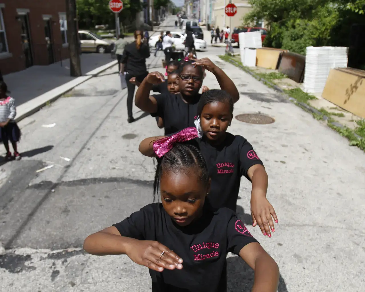 Members of local drill team Unique Miracles prepare to perform in a neighborhood procession near 3711 Melon Street, Saturday, May 31, 2014. Photo: AP/Jessica Kourkounis.