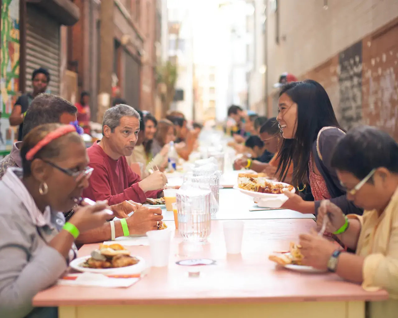 Community feast on Pearl Street, using tables and chairs designed by Walter Hood, built by community members during an Asian Arts Initiative block party. Photo by Tim Kyuman Lee.