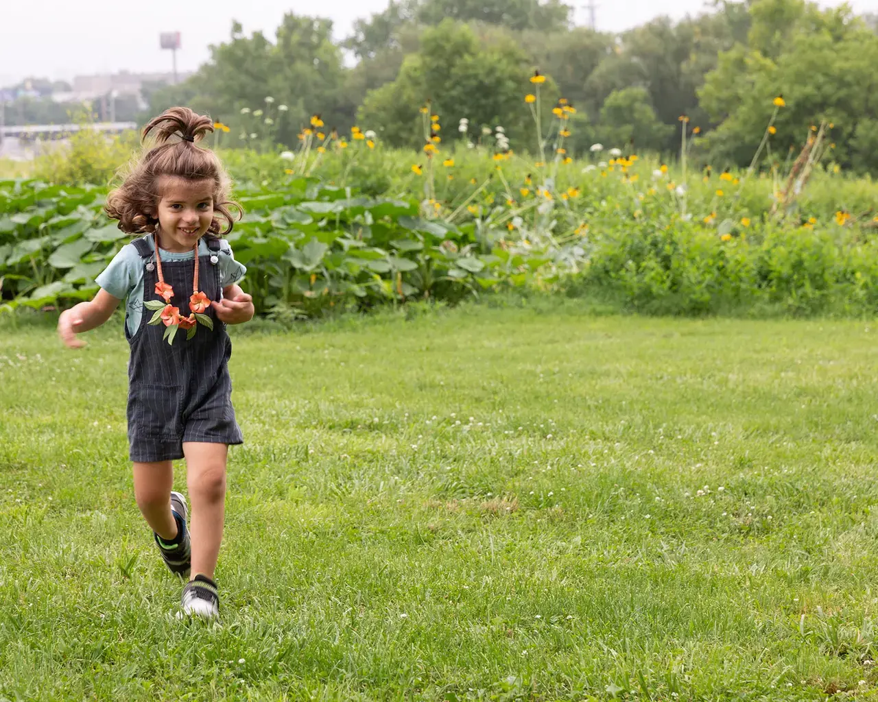 A child runs through Bartram's Garden during Al-Bustan Summer Camp. Photo by Amanda Hankerson.&nbsp;