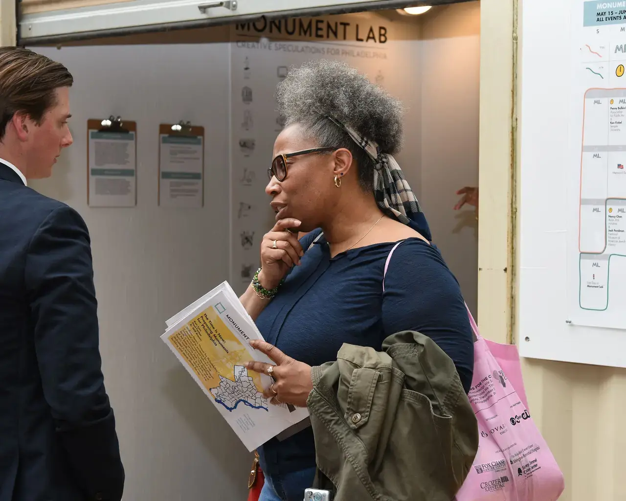 A member of the crowd brainstorms a monument at the Monument Lab \storefront\&quot; space in City Hall Courtyard