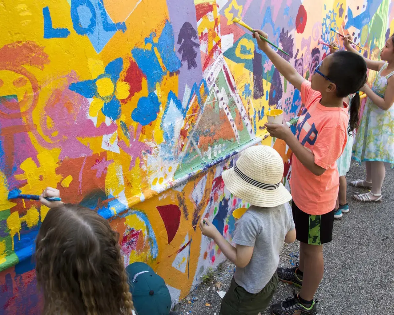 Young artists paint a mural together at Fleisher Art Memorial at a community-driven art event in South Philadelphia. Photo by Jean Solar.