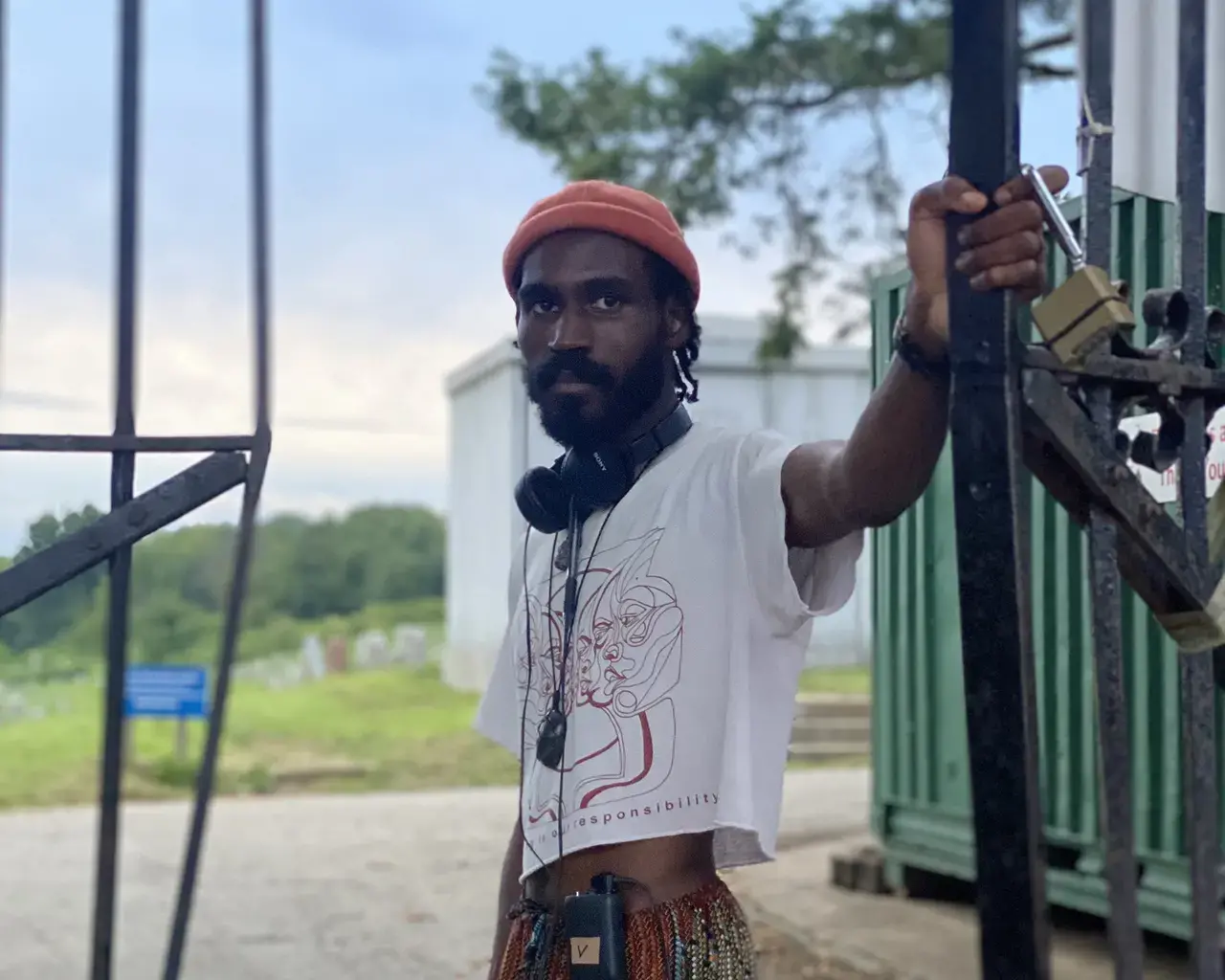 Pew Fellow Vernon Jordan lll hangs on to the door of a tall metal gate on set for "One Magenta Afternoon."