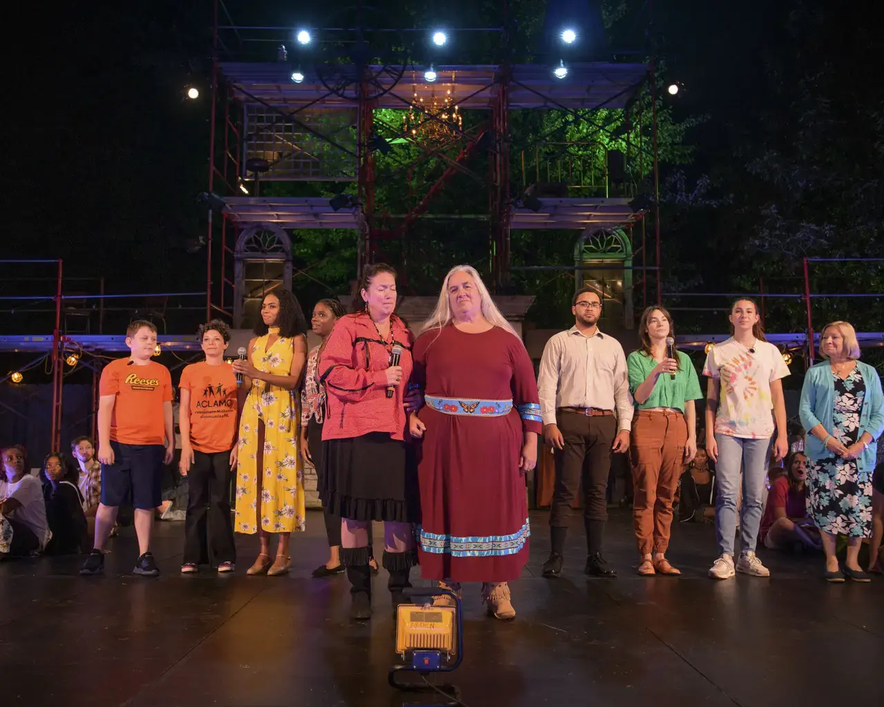 Performers in Theatre Horizon's "TOWN" line up across the stage during a performance.