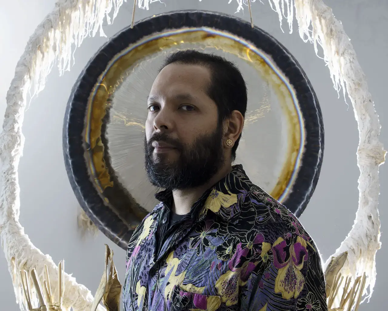 Artist Guadalupe Maravilla wears a shirt embroidered with purple and gold flowers.