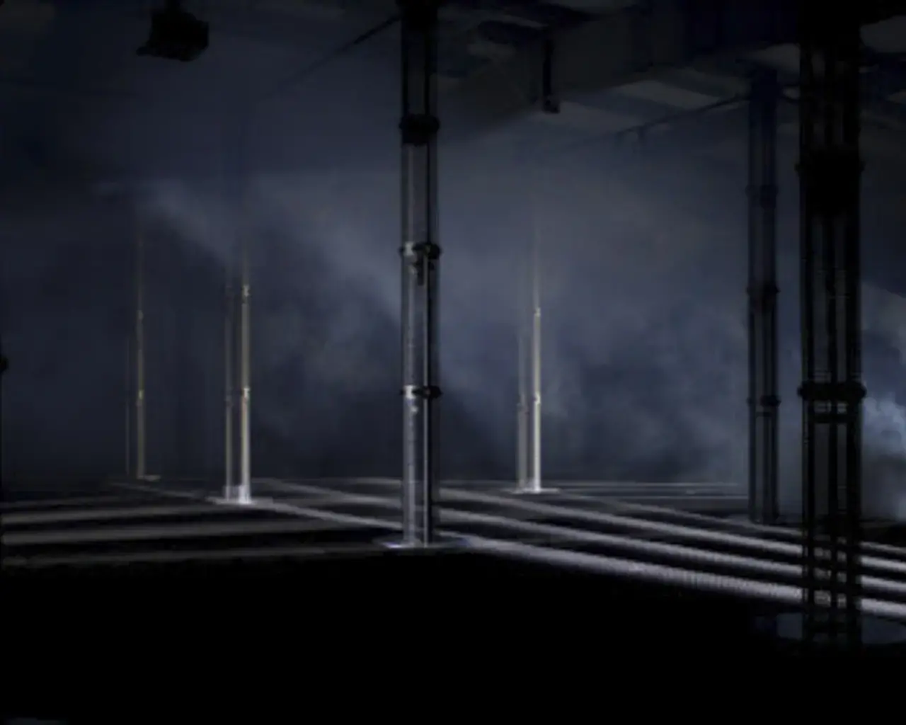 A dark room with side-lighting which casts shadows across a series of pillars that are part of a spatial sound system.