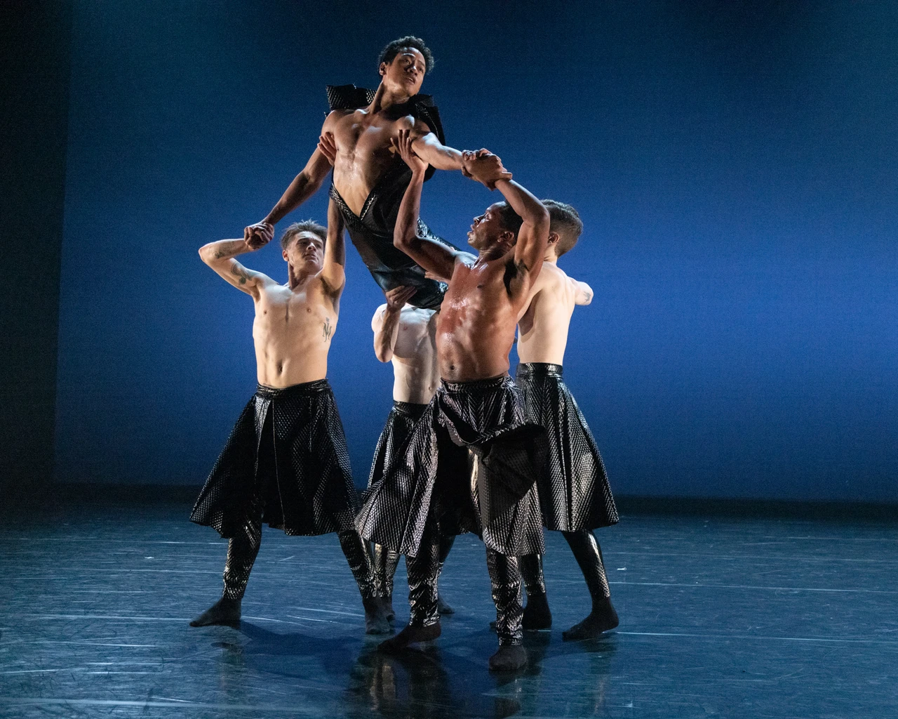 BalletX company performs choreographer Jennifer Archibald’s Exalt, 2023. Pictured: Jerard Palazo (lifted dancer), Peter Weil, Eli Alford, Jared Kelly, Ben Schwarz. Photo by Whitney Browne, courtesy of BalletX.&nbsp;