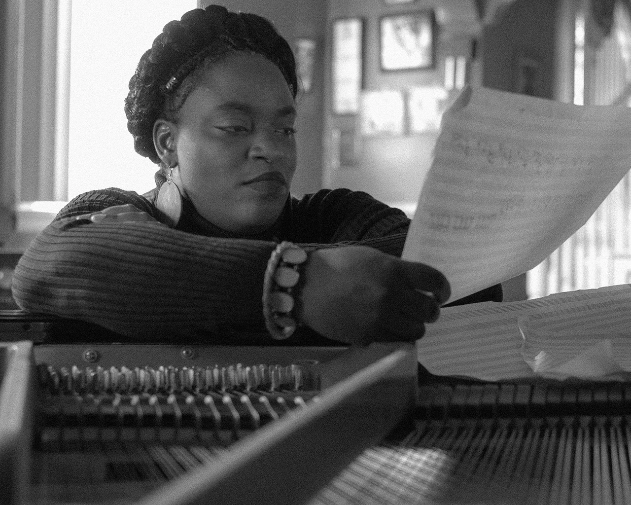 Pew Fellow Kendrah Butler-Waters sits at a piano with sheet music.