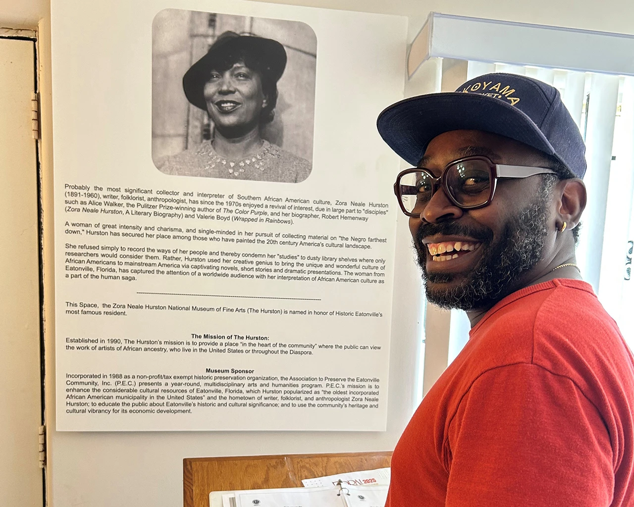 James Ijames poses in front of an exhibit at the Zora Neale Hurston Museum