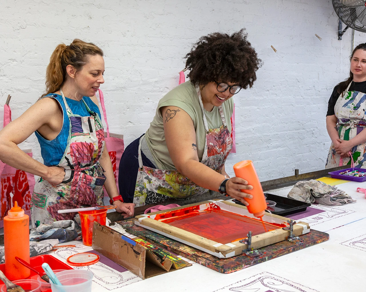 Katie Parry, Fabric Workshop and Museum Public Education Program Manager (at left), leads a screenprinting workshop in partnership with BlackStar Projects. Photo by Carlos Avendaño.