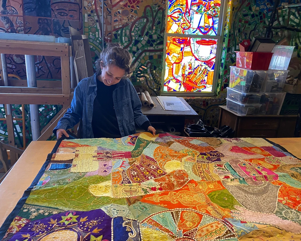 Carmen Mardonez viewing a textile from India in the Magic Gardens Studio Archives, April 2025.&nbsp;Photo courtesy of Philadelphia's Magic Gardens.