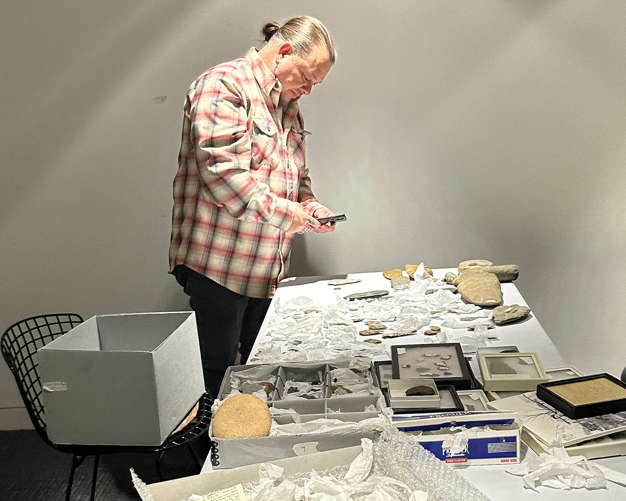 Jeremy Johnson, Delaware Tribe Cultural Education Director, examines the Lenape items in the Schwenkfelder Library and Heritage Center collections in February 2025. Photo by L. Allen Viehmeyer.