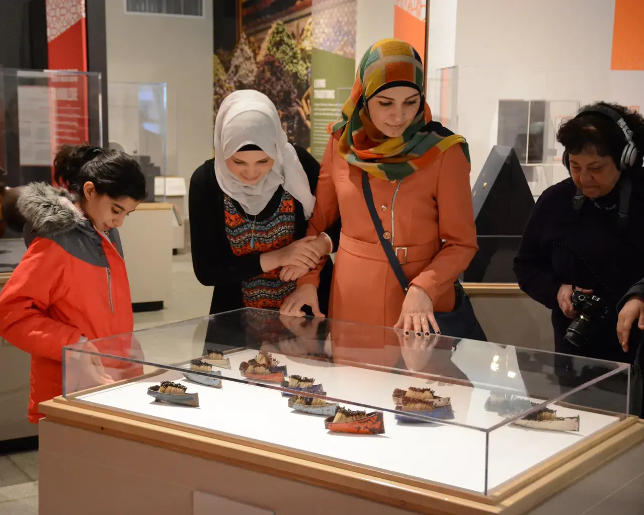 Visitors at Penn Museum&rsquo;s Cultures in the Crossfire: Stories from Syria and Iraq around a work by Syrian-born artist Issam Kourbaj. Photo courtesy of Penn Museum.