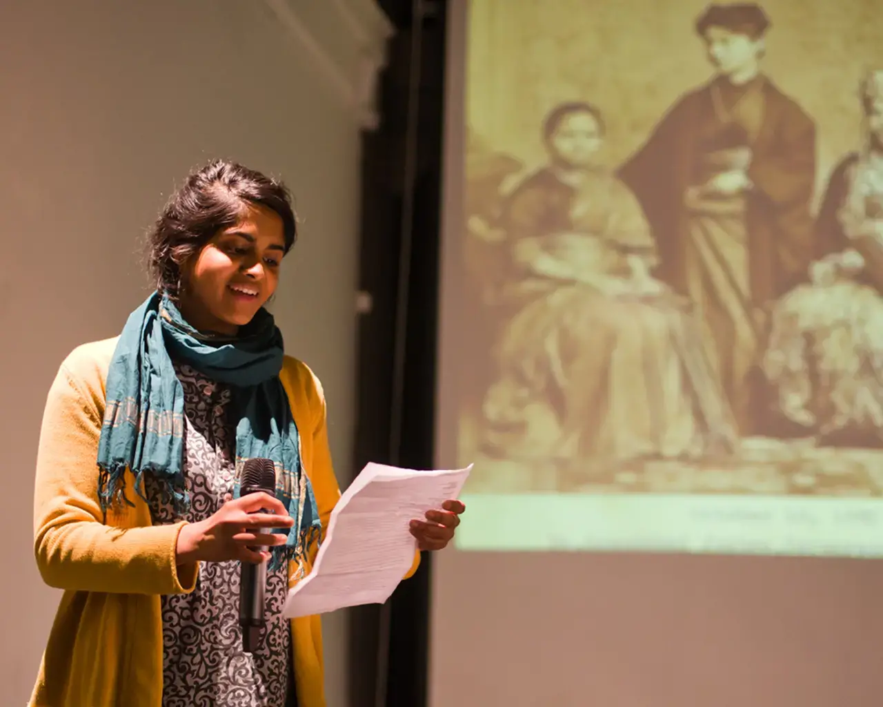 South Asian American Digital Archive, Pavi Jaisankar speaks at a SAADA Community Forum at the Asian Arts Initiative in front of a photograph of Dr. Anandibai Joshee, the first South Asian woman to earn a degree in Western medicine, 2013. Photo by Vivek G. Bharathan.