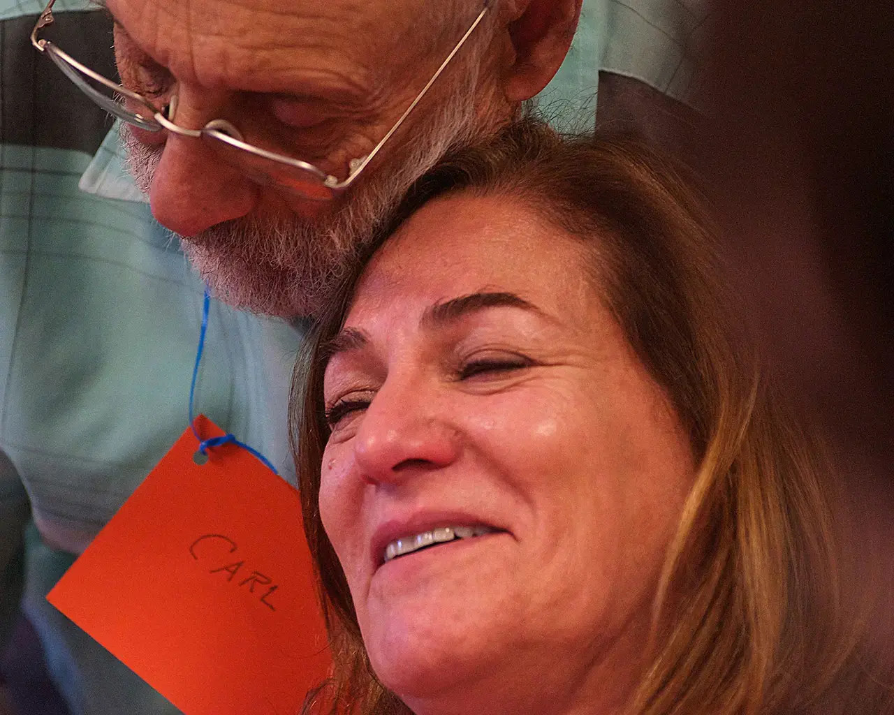 Carl D., who is living with dementia, comforts Nadine F., the care partner of another participant, during a creative workshop led by artist Teya Sepinuck. Photo by Raymond W. Holman, Jr.