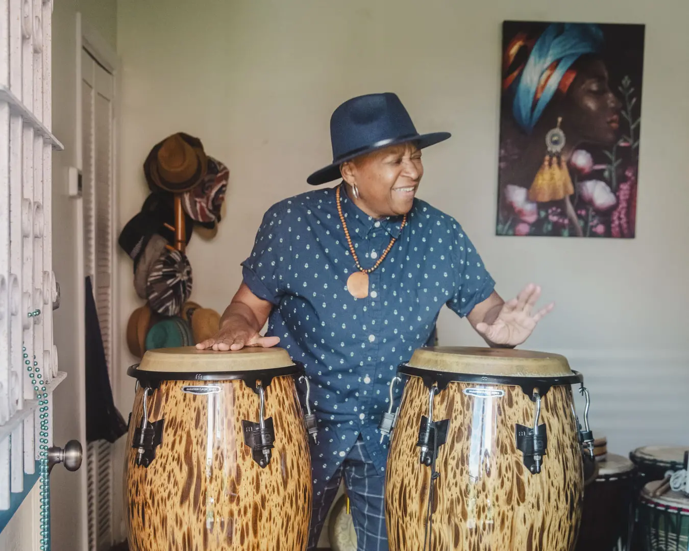 Pew Fellow Karen Smith stands playing drums.