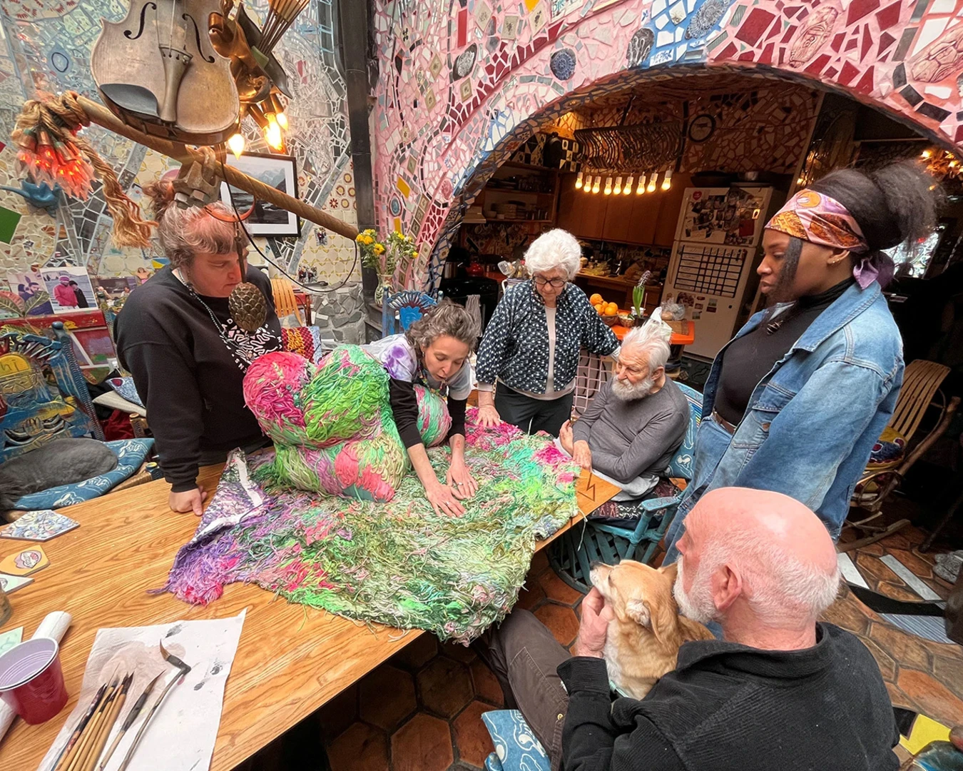 Artist Carmen Mardonez showing an example of her work in the Zagar family dining room during her residency at Philadelphia’s Magic Gardens. A 2025 Center grant supports two site-specific installations by Mardonez at Magic Gardens Museum and its newly-opened studio space. Photo by Emily Smith.
