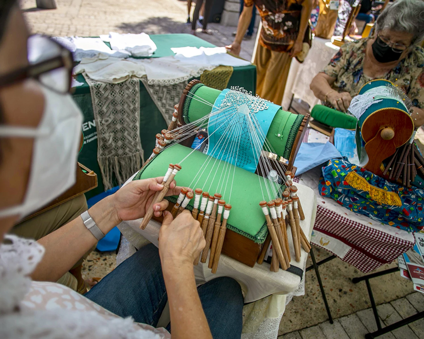 Carmen Arteaga demonstrates the intricate bobbin lace-making technique called mundillo, or “little world.” Guatemalan and Puerto Rican designers are leading textile workshops for Taller Puertorriqueño’s Tramando. Photo by Xavier Garcia, courtesy of Taller Puertorriqueño.&nbsp;