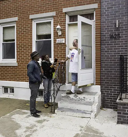 Medea Brooks and Hank Willis Thomas interview South Kensington resident Tony Garcia in November of 2015. Brooks is one of the artist collaborators working with Willis Thomas, who is the lead artist. Photo by Jordan Baumgarten/Philly Block Project.