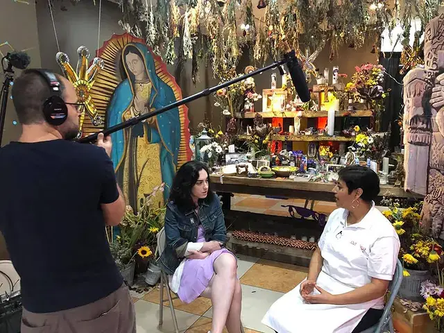 Philadelphia Folklore Project executive director Naomi Sturm-Wijesinghe (left) interviews Christina Martinez of South Philly Barbacoa at La Ofrenda, an interactive installation by Cesar Viveros. Photo by Mauricio Bayona, courtesy of the Philadelphia Folklore Project Archives.