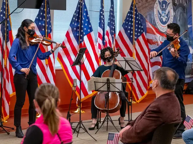 Philadelphia Orchestra musicians Julia Li (violin), Che-Hung Chen (viola), and Yumi Kendall (assistant principal cello) perform during a naturalization ceremony in West Philadelphia, part of the Orchestra's free concert series Our City, Your Orchestra, 2021. Photo by Jeff Fusco.