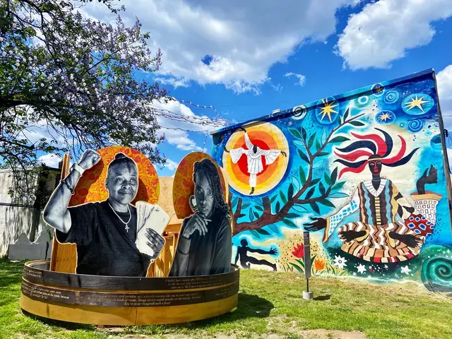 Sculpture: Courtney Bowles and Mark Strandquist, On the Day They Come Home, 2021, part of Staying Power exhibition, The Village of Arts and Humanities, Fairhill-Hartranft neighborhood, Philadelphia, Pennsylvania. Mural: Lily Yeh, Obatala, 2018. Photo courtesy of The Pew Center for Arts &amp; Heritage.