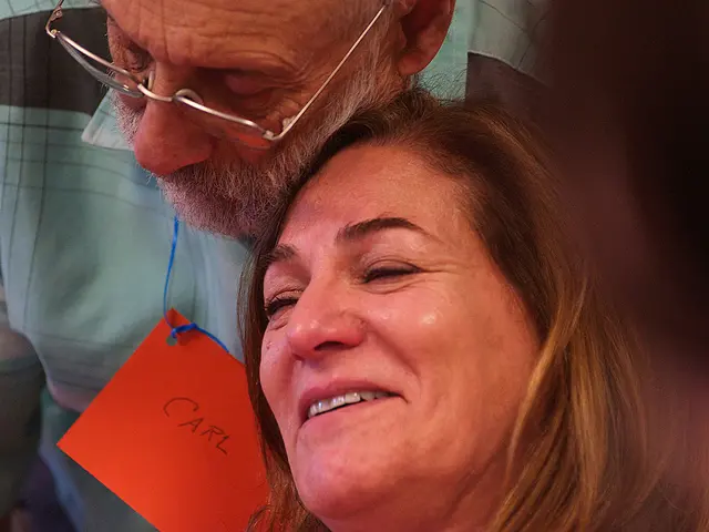 Carl D., who is living with dementia, comforts Nadine F., the care partner of another participant, during a creative workshop led by artist Teya Sepinuck. Photo by Raymond W. Holman, Jr.