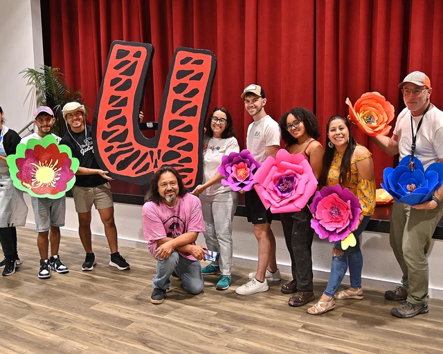 Alba Martínez (center) with community members working together on the La Guagua 47 float during the Puerto Rican Day Parade. Photo taken by Jesús Rincon.&nbsp;